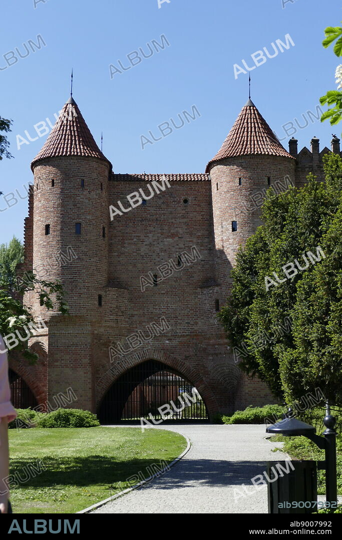 Photograph of the Warsaw Barbican (Barbakan Warszawski) is a barbican (semi-circular fortified outpost) in Warsaw, Poland, and one of few remaining relics of the complex network of historic fortifications that once encircled Warsaw. The barbican was erected in 1540 in place of an older gate to protect Nowomiejska Street. It was designed by Jan Baptist the Venetian, an Italian Renaissance architect. Dated 21st Century.