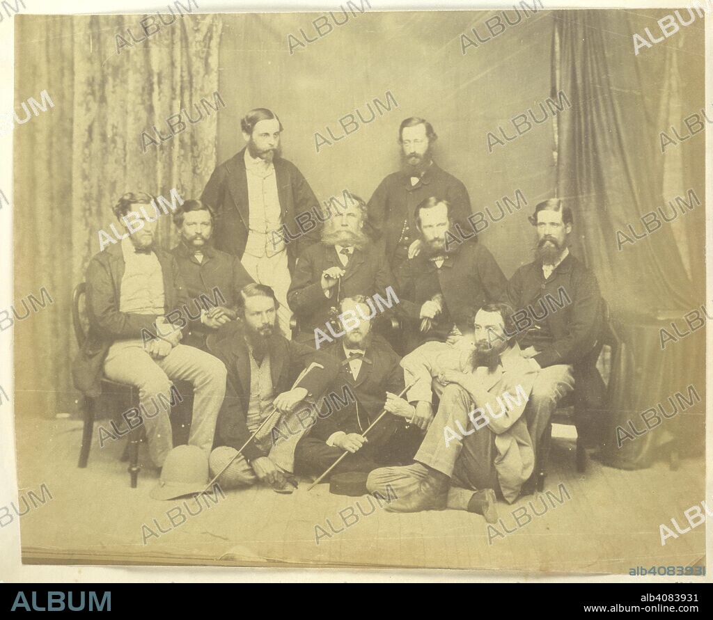 Rajpootana Agency. A group portrait of Colonel Sir George Lawrence and officials.  The photographer Eugene Impey is sitting second from right, but it is assumed that Taylor, who was Officiating Assistant to the Agent to the Governor-General of Rajputana at the time, was behind the camera. Captain Charles Walter is standing on the left. Murray Collection: Agra Album. Views and portraits, mainly in and around Agra. 1862. Photograph. Source: Photo 835/(321).