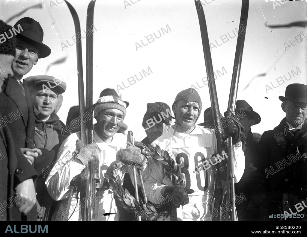 Göteborg 11 mars 1928 Vasaloppet. 1928 åkte Per-Erik Hedlund nu för Särna och Sven Utterström, Boden, dött lopp och åkte i mål hand i hand på tiden 5.33.23. Båda "trädde armarna i lagerkransen och läto film- och kameramän föreviga det stolta ögonblicket". Kranskulla: . Stina Eriksson . Foto: Kamerareportage *** Local Caption *** . KAMERAREPORTAGE.