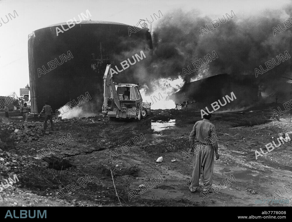 Guerre Iran-Irak (22.09.1980 - 20.08.1988) / Front iranien. Dans l'attaque d'une sucrerie située à une trentaine de kilomètres de la frontière irakienne, des roquettes lancées par des MIG's irakiens ont enflammé les dépôts d'essence. On essaie de maîtriser le feu avec du sable amené par un tracteur. Photo 11.10.1980.