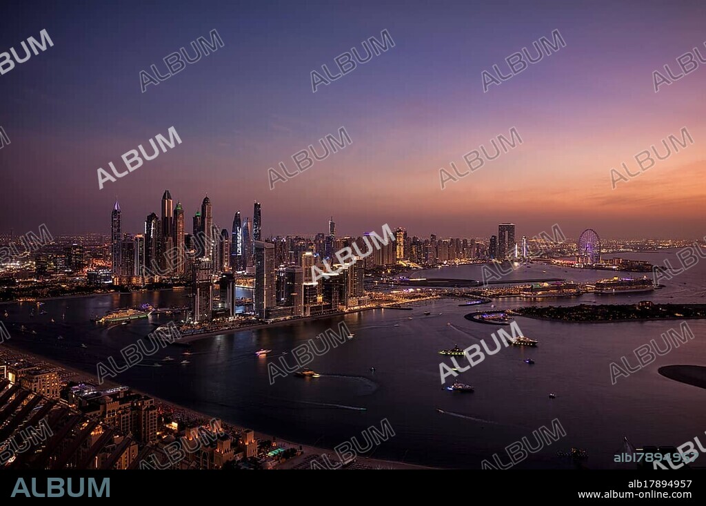 Night shot, view from The View At the Palm viewing platform of skyline with Princess Tower, Elite Residence, Ain Dubai Ferris wheel, luxury yacht OPERA owned by Sheikh Mansour bin Zayed Al Nahyan from the ruling family of the Emirate of Dubai, anchored in front of EMAAR Beachfront, logo, DAMAC, evening mood, Dubai Marina, Dubai, United Arab Emirates, VAR