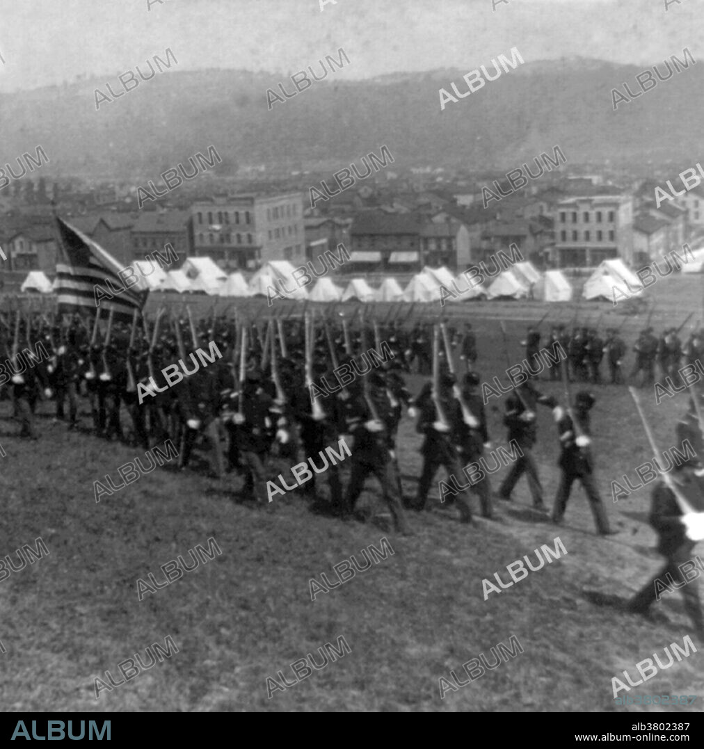 Entitled: "Under martial law - State Militia entering Homestead, Pennsylvania." The Homestead Strike was an industrial lockout and strike which began on June 30, 1892, culminating in a battle between strikers and private security agents on July 6, 1892. The battle was the second largest and one of the most serious disputes in US labor history second only to the Battle of Blair Mountain. The dispute occurred at the Homestead Steel Works in the Pittsburgh area town of Homestead, Pennsylvania, between the Amalgamated Association of Iron and Steel Workers (the AA) and the Carnegie Steel Company. The final result was a major defeat for the union and a setback for efforts to unionize steelworkers. Cropped stereograph, Underwood & Underwood, 1892.