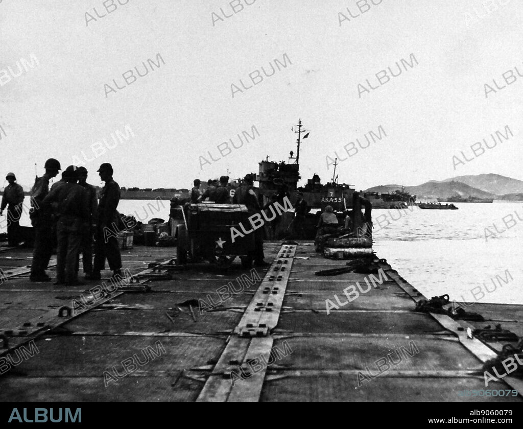 Korean War: Inchon Invasion, September 1950. U.S. Navy Seabees unload equipment from USS Alshain (AKA-55) at pontoon pier at Wolmi Do Island, Korea, September 17, 1950.