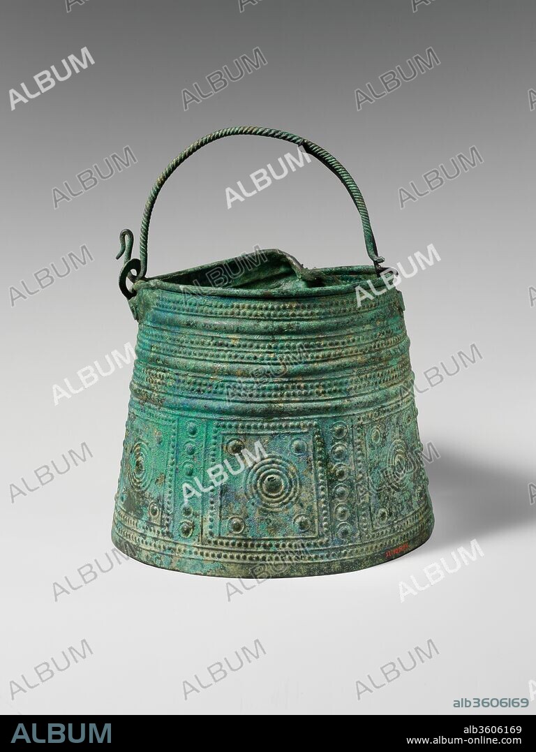 Bronze situla (bucket). Culture: Villanovan. Dimensions: H. 6 3/8 in. (16.2 cm); diameter of bottom  7 3/4 in. (19.7 cm). Date: 8th century B.C..
The precise function of early vessels like this one is unknown. However, by the sixth century B.C., similar objects were represented as banqueting vessels with wine or some other drink being ladled from them. Interestingly, the decorative patterns on the lower portion of this example are precisely paralleled on contemporaneous bronze shields.