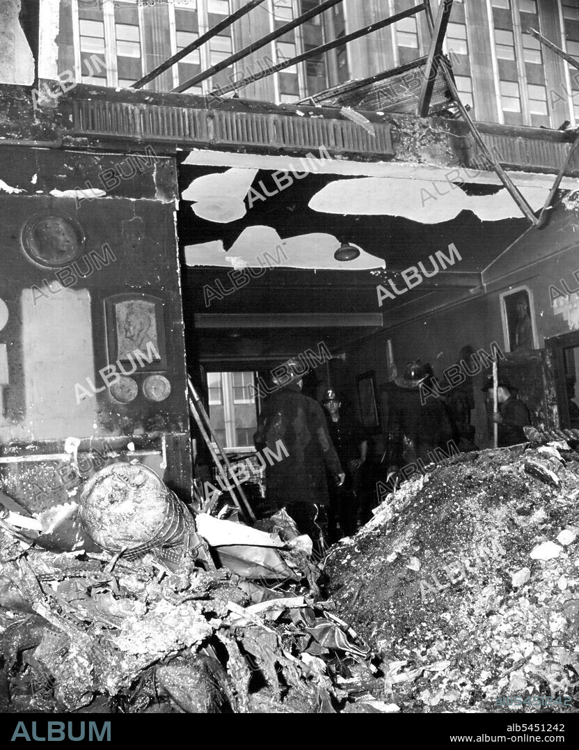 Where Plane Wreckage Hit Sculptors Penthouse -- Engine and part of wing of plane which crashed into the Empire State building in New York, July 28, a revisible in this picture taken in the penthouse studio of a sculptor in a building on 33rd street, across the street from the south side of the Empire State building, windows of which are seen at top of picture. July 28, 1945. (Photo by Associated Press Photo).