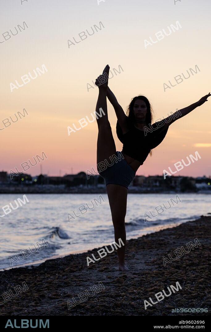 mujer joven practicando yoga, playa de Sa Rapita, Campos, Mallorca, balearic islands, Spain.