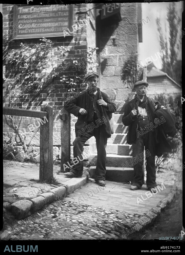 KATHERINE JEAN MACFEE. The Crown Inn, Groombridge, Speldhurst, Tunbridge Wells, Kent, 1911. Two labourers standing posed beside steps outside The Crown Inn in Groombridge.