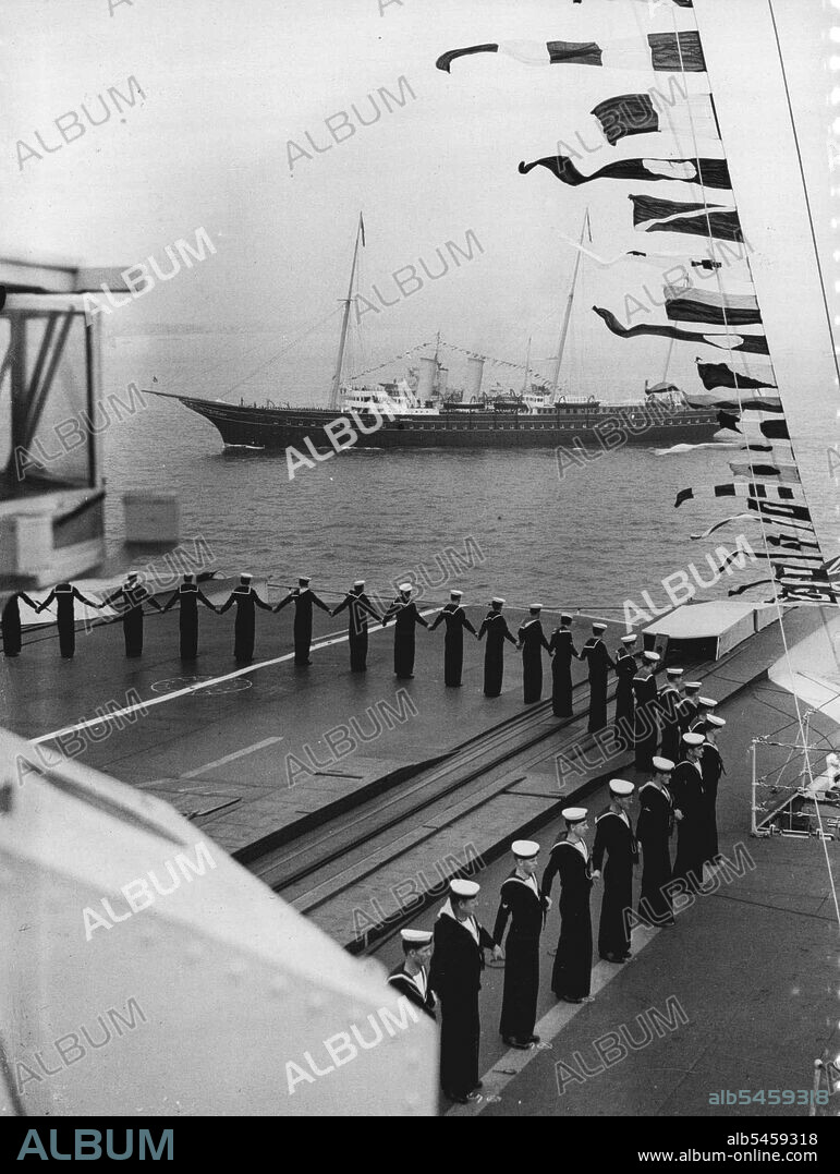The King Reviews His Fleet At Spithead - The Royal yacht "Victoria and Albert", passing the aircraft-carrier "Glorious" as the crew dressed ship.Aboard the Royal yacht "Victoria and Albert, the King passed through the five-mile lines of 160 warships and merchant vessels when he made his Coronation Review of the British Navy and Mercantile Marine at Spithead. Nearly 300 ships, including 17 from foreign fleets, were reviewed. May 20, 1937.