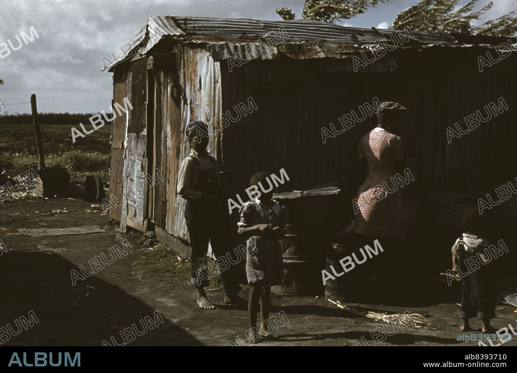 MARION POST WOLCOTT. Negro migratory workers by a shack, Belle Glade, Florida.