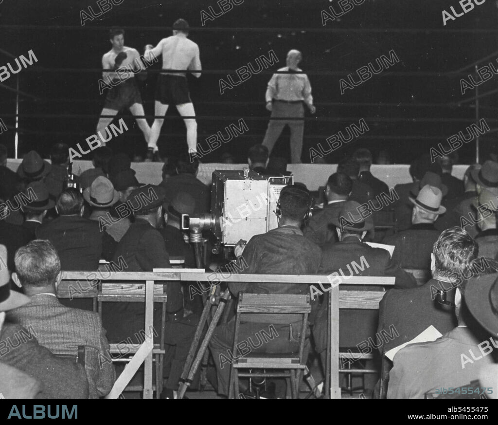 Television "Covers" Fight For First Time -- For the first time in the history of television, the television cameras were taken to a ringside when the Max Baer-Lou Nova fight at the Yankee Stadium, June 1st, was televised. Here is the scene at the ringside during the semi-final bout between Max Marker and Wally Sears as the television camera is trained on the fighters. The main bout was televised in the same fashion. December 3, 1952. (Photo by ACME).
