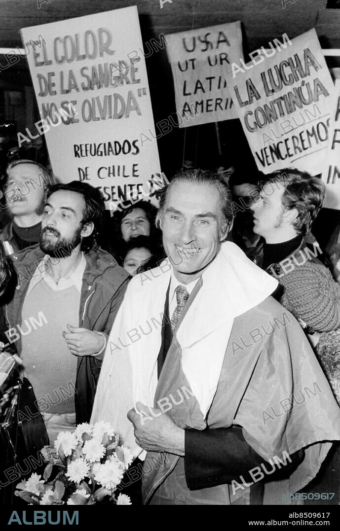 Stockholm 1973-12-10. Harald Edelstam, Sveriges ambassadör i Chile, insvept i den chilenska flaggan, möttes av chilenska flyktingar när han anlände till Arlanda . Foto: Jan Björsell / SvD / TT / kod 12014.