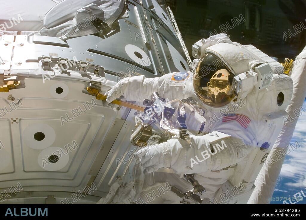 Astronaut James H. Newman, waves at camera during the early stages of a 7-hour, 21-minute spacewalk on the first mission of the Space Shuttle to the International Space Station, December, 1998. Astronauts Newman and Jerry L. Ross, both mission specialists, went on to mate 40 cables and connectors running 76 feet from the Zarya control module to the Unity connecting module, with the 35-ton complex towering over Endeavour's cargo bay.