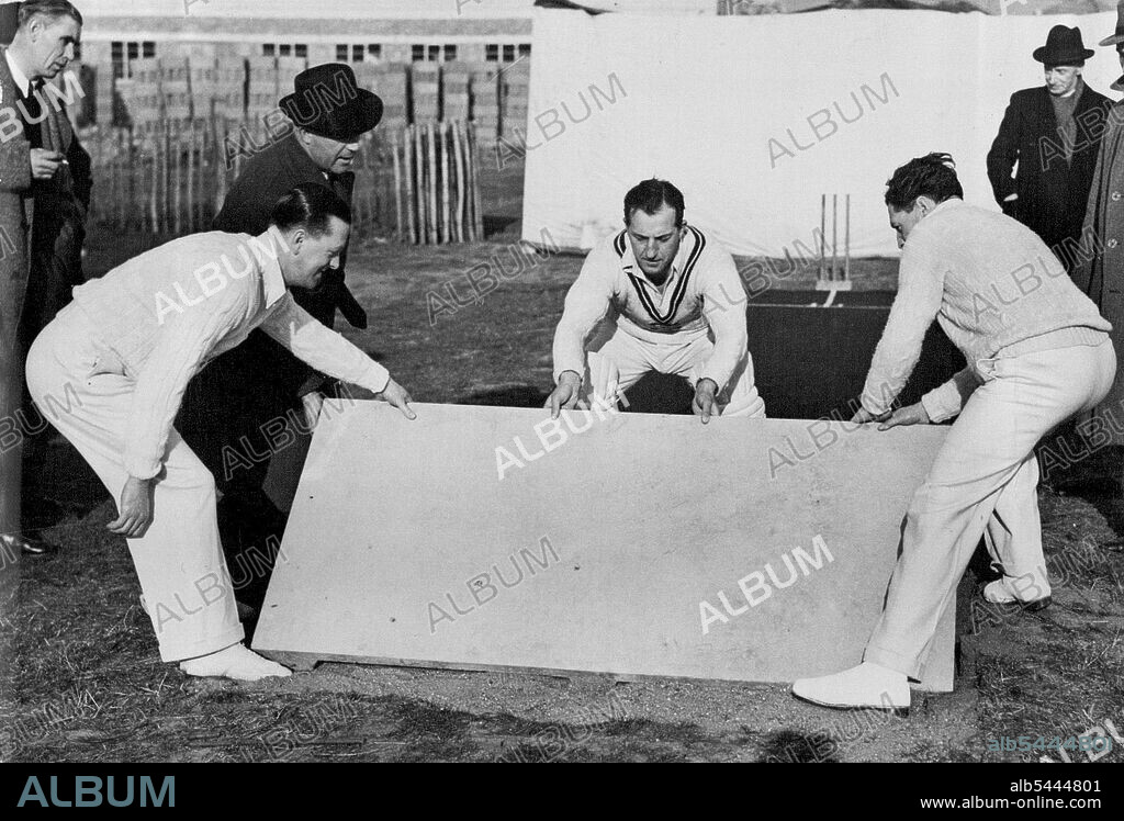 A New Concrete Cricket Pitch -- Left to Right: Len Muncer, of Glamorgan; Bill Edrich, England and Mieddlesex; and Eddie Ward, of the Chiswick school demonstration the easy laying of the concrete sections of the pre-cast cricket pitch. March 04, 1949. (Photo by Sport and General Press Agency Limited).