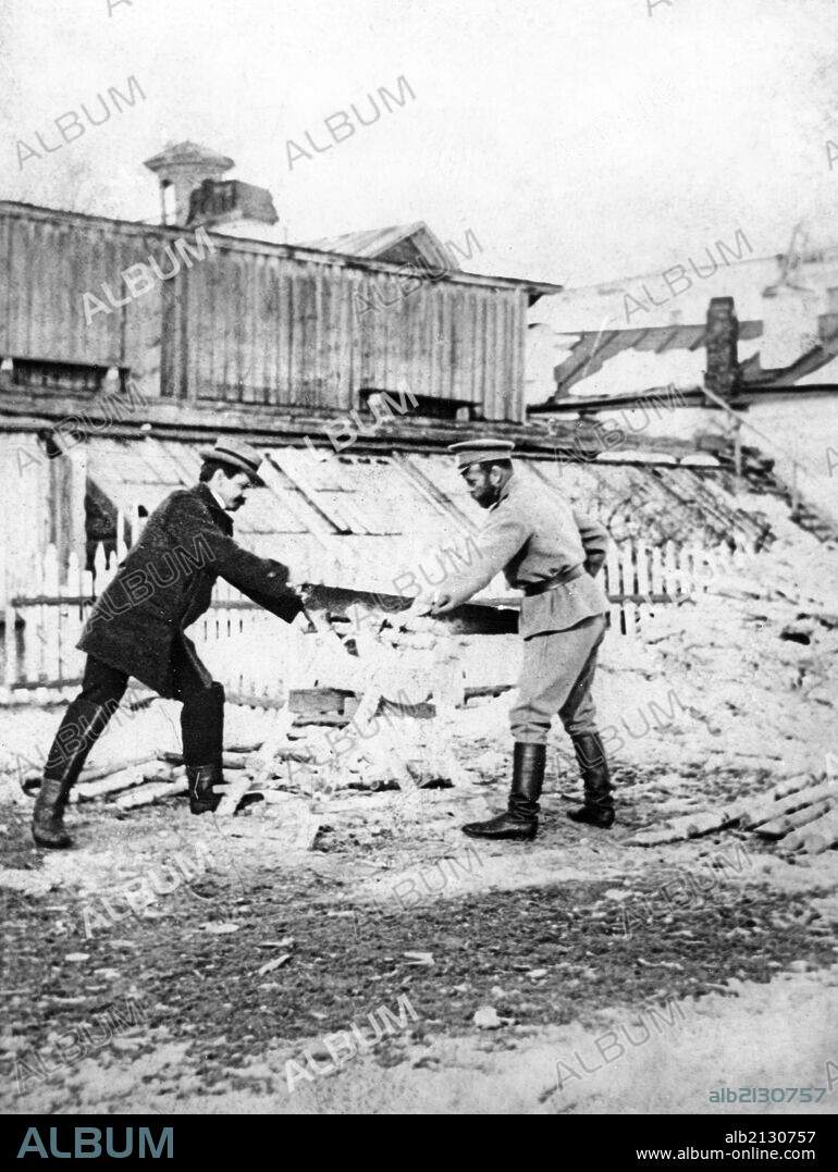 Tsar nicholas ll cutting wood with pierre gilliard, the tutor of tsarevich (prince) alexei, during their imprisonment in tobolsk in 1918.