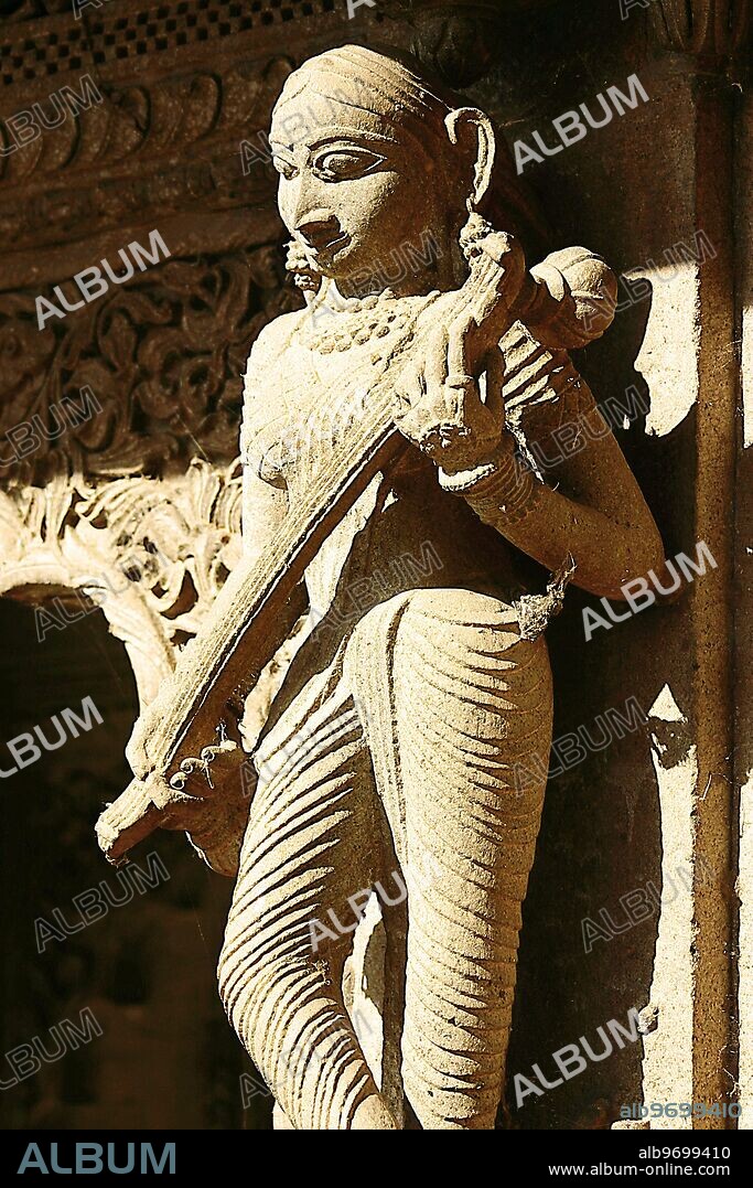 RSC75069 : Indian musician, woman playing Veena, carved on wall of Ahilyabai temple, ornamental carving on stone, old Indian sculpture, Heritage site, in building on Ahilyabai ghat of Narmada river, was named after Ahilyabai, one of the most powerful ruler of Holkar dynasty of Indore, Maheshwar, Madhya Pradesh, India. -.