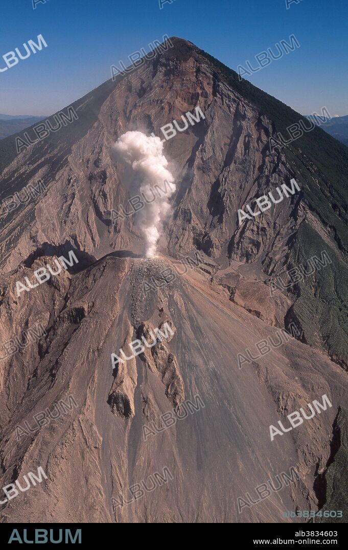 Eruption of the Santiaguito Dome Volcano (Santa Maria), located near the city of Quetzaltenango in the Sierra Madre Mountain range of Guatemala. High concentrations of silica glass and gases in the thick dacitic lava produced by the volcano plug the vent until enough pressure builds up and causes a violent explosive eruption. In 1902 this volcano had the second largest volcanic eruption in the twentieth century killing hundreds of people. Photograph taken from the south on February 2, 1999.