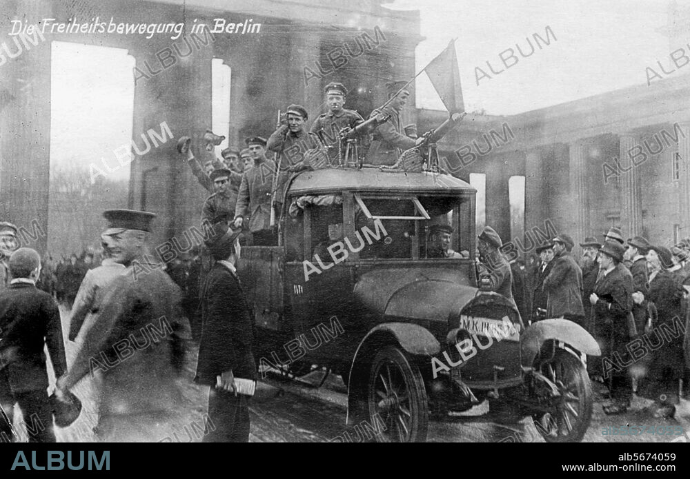 Novemberrevolution 1918:. Truppenteile schließen sich den Streikenden an, Berlin, 9. November 1918. Soldaten mit einer Roten Fahne fahren durch das Brandenburger Tor. Foto. Berlin, Sammlung Archiv für Kunst und Geschichte.