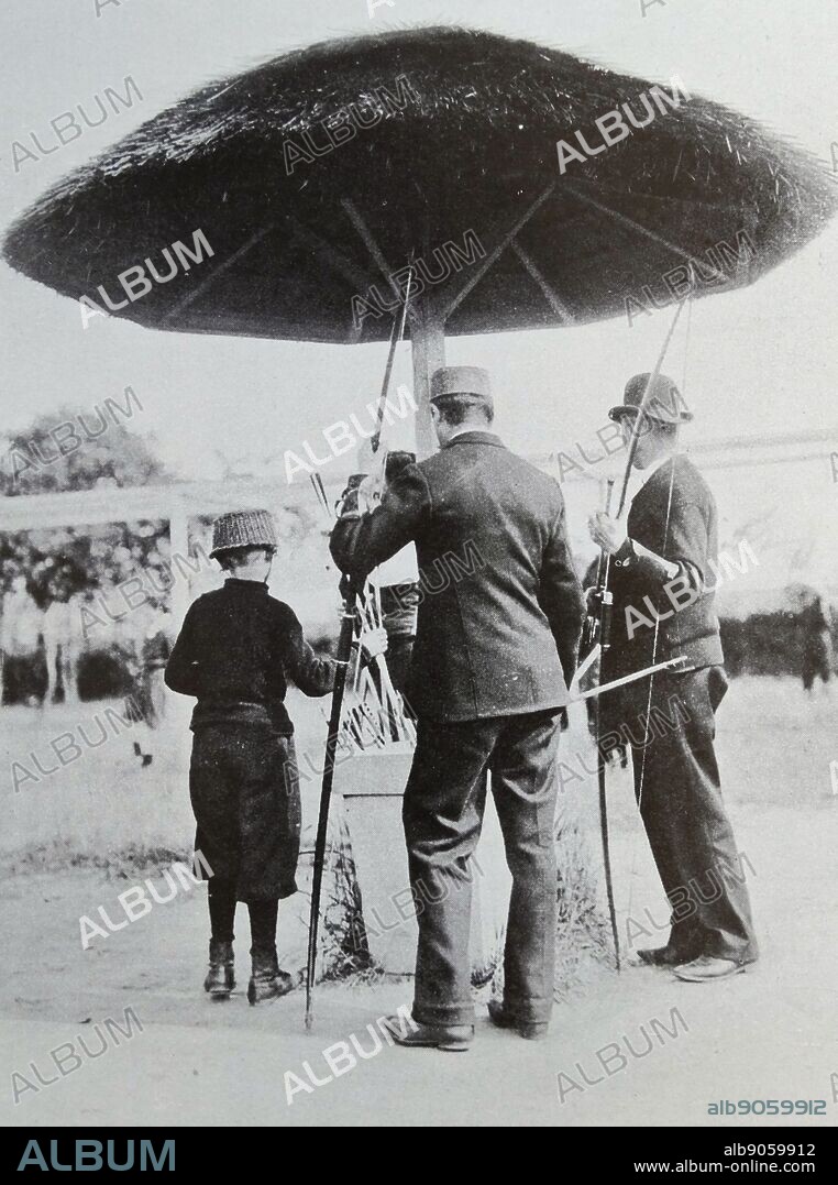 The mushroom head protector used in an archery contest, Belgium 1914. Under this structure we see two archers picking arrows for their next shot. The leather 'brassards' on their arms are supposed to protect their wrists against injury caused by the string when the arrow is released.