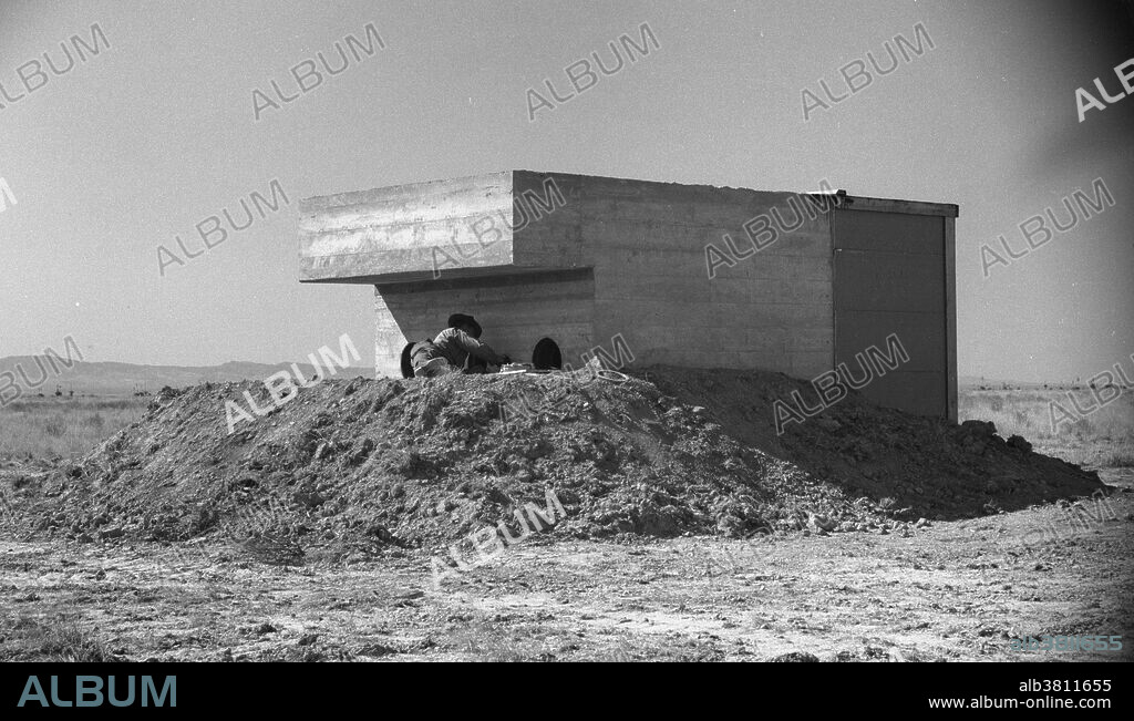Trinity Test Site. The Manhattan Project was a research and development program by the US with the UK and Canada that produced the first atomic bomb during WWII. From 1942-46, the project was under the direction of Major General Leslie Groves of the US Army Corps of Engineers. Because of the complexity of an implosion-style weapon, it was decided that an initial test would be required. Groves approved the test, subject to the active material being recovered. Consideration was therefore given to a controlled fizzle, but Oppenheimer opted instead for a full-scale nuclear test, codenamed Trinity. Bainbridge selected the bombing range near Alamogordo Army Airfield as the site for the test. A base camp was built to house staff. A one-hundred foot shot tower was designed and constructed at ground zero. Concrete bunkers to house cameras and other diagnostic equipment popped up in a rough circle around ground zero. A commitment had been made to test the gadget "as soon after July 15th as possible," and before or during the upcoming Potsdam Conference. TNT Trinity Test occured on July 16th.