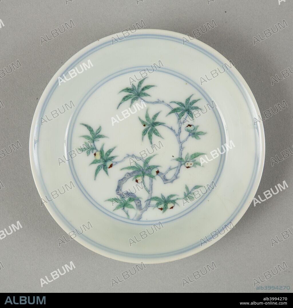 saucer dish with flat bottom and angled flaring sides. The central medallion has a fruiting peach tree. The medallion and rim both have double underglaze blue lined borders, the reverse has similar borders and two peach trees. The base has a six-character underglaze blue mark of Chenghua (1465-1487), written in late Kangxi style.