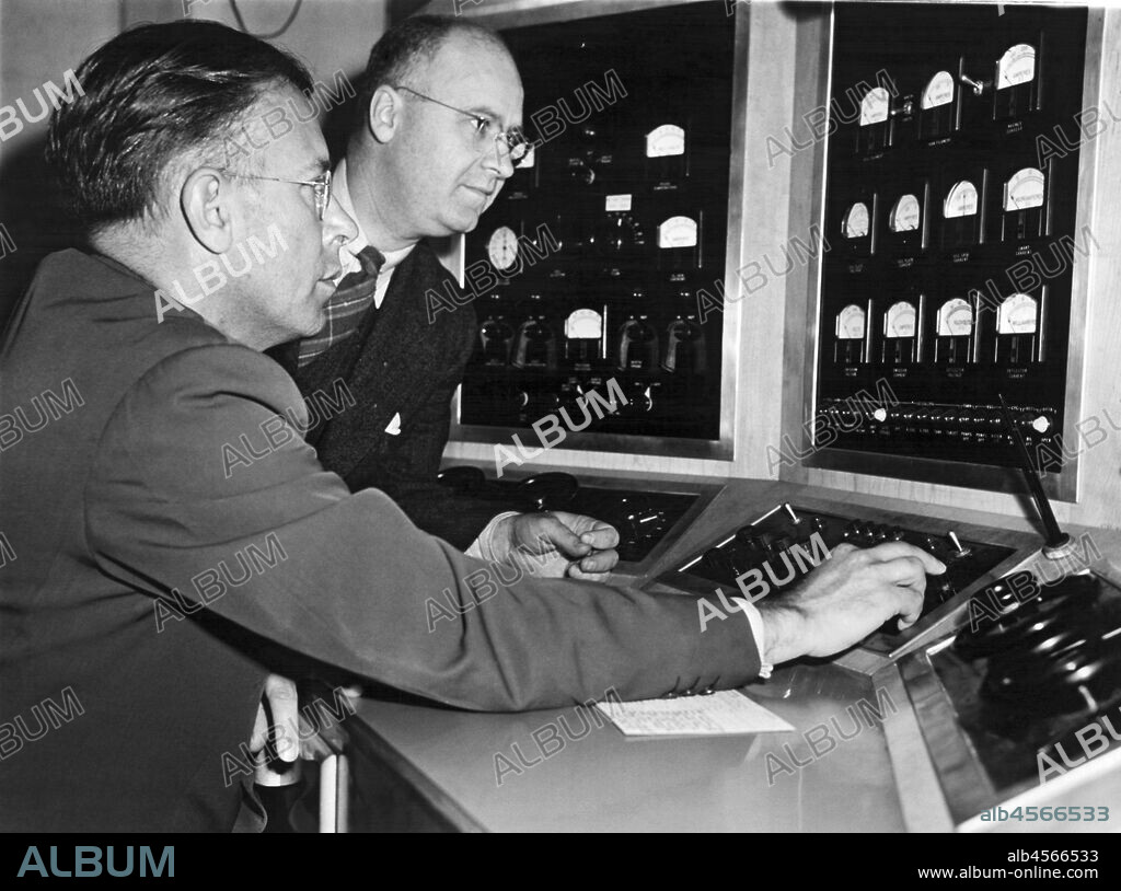 Berkeley, California, August 10, 1945 University of California's Dr. Ernest Lawrence, inventor of the cyclotron, and UC engineer WB Reynolds, examine the control panel of the 60 inch atom gun which is being used in the making of the first atomic bomb.
