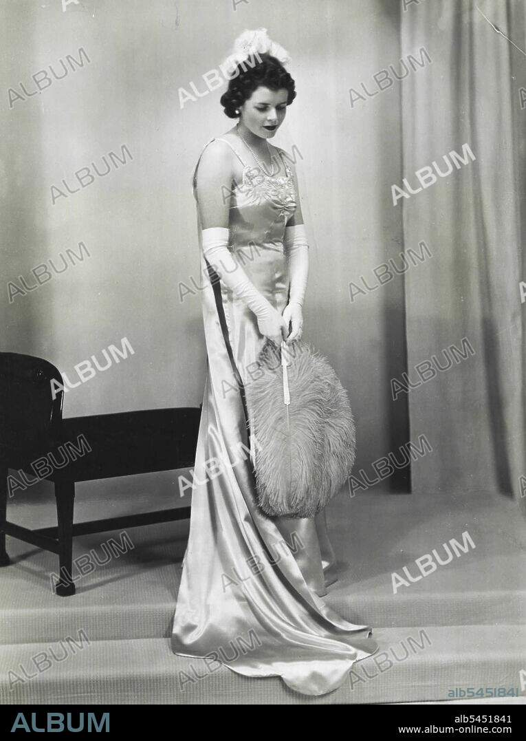 Miss Valerie Downes - Second daughter of Major General Rupert Downes C.M.G.. V.D.. and Mrs. Rupert Downes who was presented by Mrs. Bruce wife of the High Commissioner for Australia on July 12th. Gown of deep shell pink satin appliqued in pearls to tone with train to match. Carried shaded pink fan to tone with dress. July 31, 1939.
