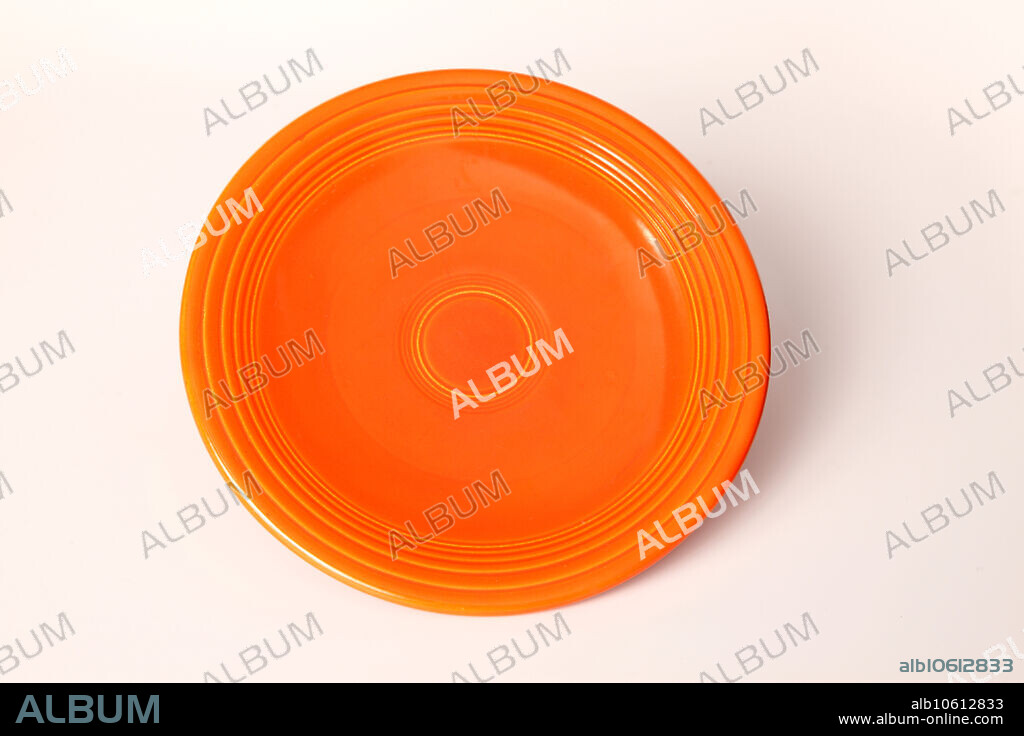 This is a radioactive ceramic plate called Fiesta ware, produced by the Homer Laughlin Company of West Virginia. The orange glaze produced by this company in the 1930's used uranium oxide in the glaze. Measurements have indicated that, up to 14% of the glaze can be uranium.