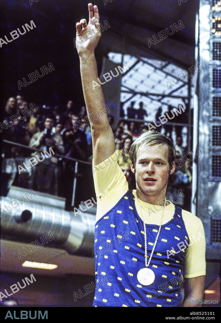 MÜNCHEN 1972. Svenske simmaren Gunnar Larsson sträcker armen i skyn med guldmedaljen runt halsen ståendes på prispallen efter ett av sina två guldlopp i simning vid de olympiska sommarspelen i München, Västtyskland i augusti och septemeber 1972.. Foto: EPU / TT / Kod: 193.