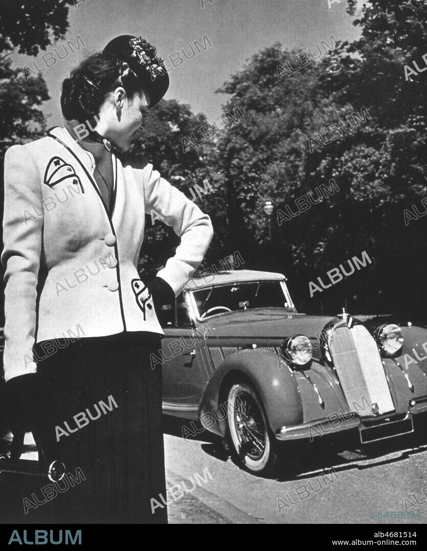 Tailleur en lainage blanc Nina RICCI devant une voiture cabriolet Talbot 4L dans L'Art et la Mode en 07/1939. Credit: Collection KHARBINE-TAPABOR.