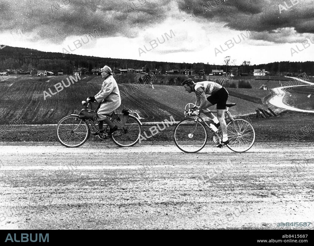 ARKIV Årets Bild 1967 - "Tanten på cykeln". Bilden föreställer en dam på väg till Konsum som hamnat mitt i sexdagarsloppet. Erik Fåglum tävlar med den äldre damen. Ersätter bild 175899. Foto: Lasse Olsson Kod: 45 . COPYRIGHT SCANPIX SWEDEN.