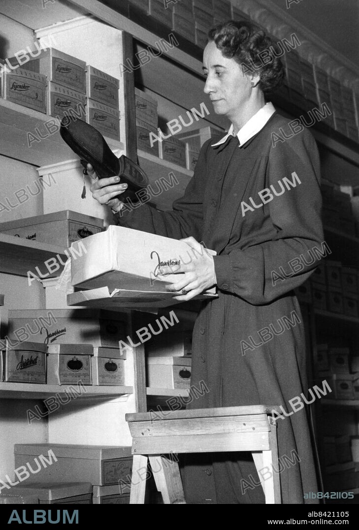Skobutik skoaffär skohandel i Malmö 1950. Biträde med sko skokartong hylla. Foto: Sydsvenskan / IBL Bildbyrå.
