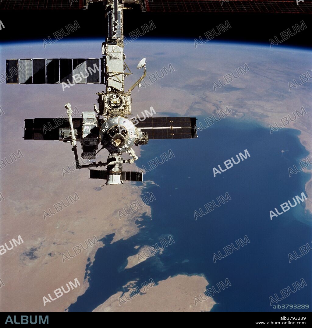 STS-104, Space Shuttle Atlantis launched on July 12, 2000. The ISS passes over the Persian Gulf. The photograph was taken with a 70mm handheld camera during a fly-around inspection by the Space Shuttle Atlantis not long after the two spacecraft separated. Prominent on the starboard side of the outpost is the newly-installed Quest airlock. The primary payload on the mission was the joint airlock module, which will require two spacewalks to attach it to the Space Station. The airlock will be the primary path for Space Station spacewalk entry and departure for U.S. spacesuits, and will also support the Russian Orlan spacesuit for EVA activity. The Joint Airlock is 20 feet long, 13 feet in diameter and weighs 6.5 short tons. The ISS-airlock has two main components: a crew airlock and an equipment airlock for storing EVA gear and EVA preflight preps. STS-104 also carried a spacelab pallet with four High Pressure Gas Assembly containers that were attached to the exterior of the airlock.