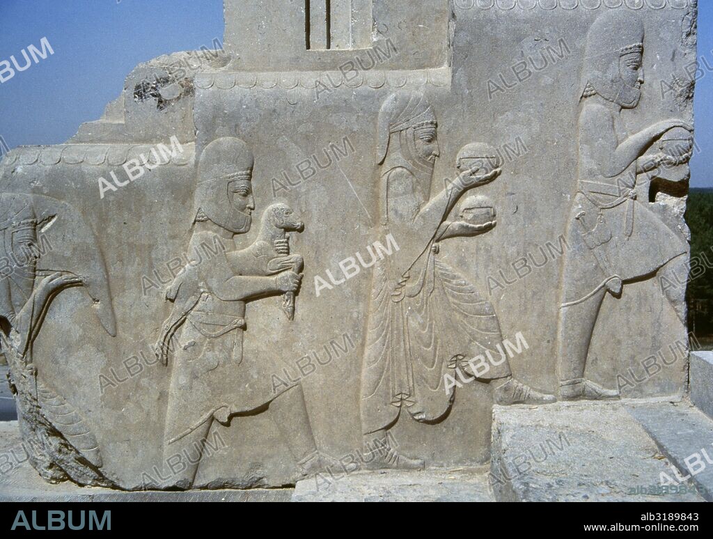 ARTE PERSA-AQUEMENIDA. PERSEPOLIS. Relieves escultóricos de las escalinatas de LA APADANA (SALON DE RECEPCIONES DE DARIO), en los que se narran los fastos del Año Nuevo. Detalle de la ENTREGA DE TRIBUTOS AL REY PERSA POR PARTE DE UNA NACION VASALLA (CILICIANOS). ESCLAVOS LLEVANDO LOS REGALOS. Relieve del sector sur. EPOCA DE DARIO I (522-486 a. C.). República Islámica de Irán.
