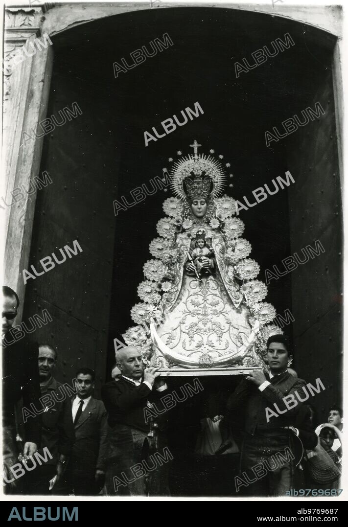 Rocío Rocío 08. On May 14, 1964, being Antonio Romero Algarín's older brother, the last processional departure of the Virgin of Rocío that is venerated in El Salvador took place to go to the parish church of San Juan de Aznalfarache, in the cart of the simpecado of the brotherhood of Seville. In 1962 and 1963, being Gabriel Rojas Fernández's older brother, the Virgin had already stayed in El Salvador. In the Image, the moment of the departure of the Virgin, on the Shoulders of Brothers, to be deposited in the cart of simpecado and begin the march towards San Juan de Aznalfarache. Highlander.