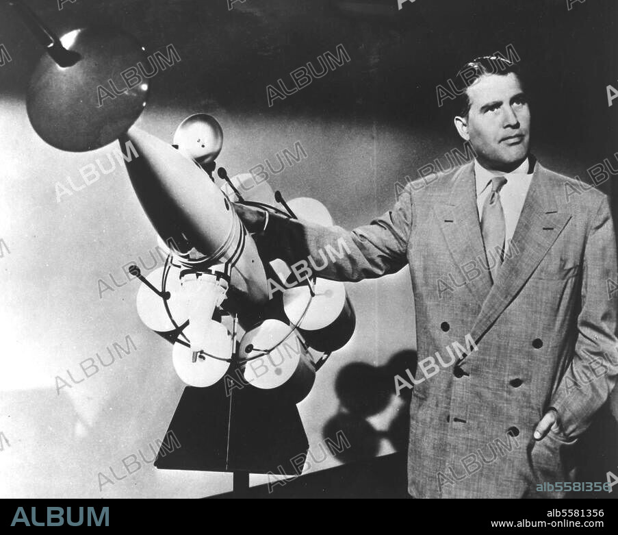 Braun, Wernher Freiherr von Physiker und Raketenkonstrukteur. 1912-1977. Wernher von Braun erklärt sein Modell eines bemannten Raumschiffs für einen Flug zum Mond. (Szene aus dem Walt-Disney-Film "Morgen zum Mond"). Foto, 11.11.1957.