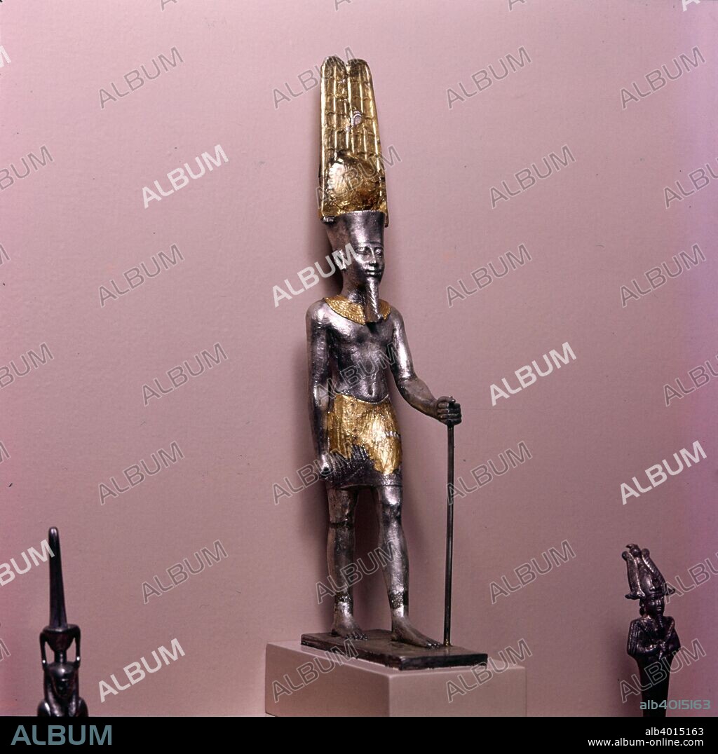 Statuette of Amen-Ra,  Late New Kingdom c900BC. His crown is topped by two tall feathers and a sun disk, symbolic of his assimilation with the sun god, Ra, as Amun-Ra.  Silver overlaid with gold foil, Egyptian. British Museum.