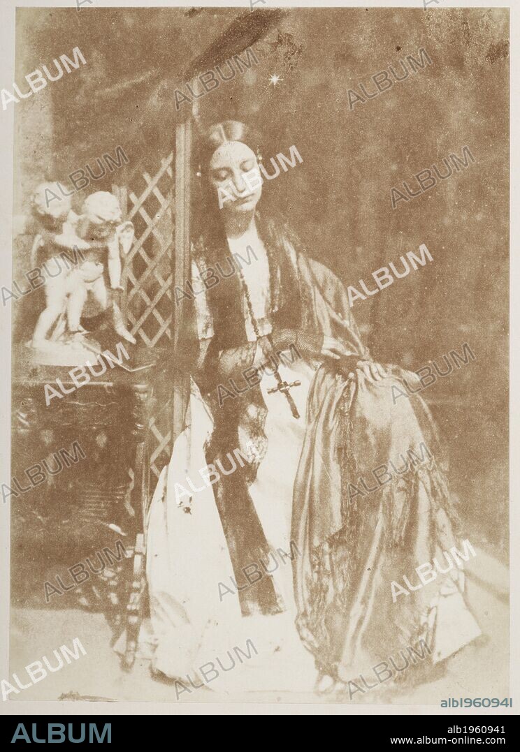Julieta, a study (Elizabeth Rigby, later Lady Elizabeth Eastlake). Full-length seated portrait, the sitter either sleeping or gazing downwards, wearing a large cross hanging from a necklace. One Hundred Calotype Sketches. Edinburgh, 1848. From a volume of calotype images and portraits. Early photographic technique also called Talbotype. Dating from 1849. David Octavius Hill and Robert Adamson. Source: C.128.k.10 59.