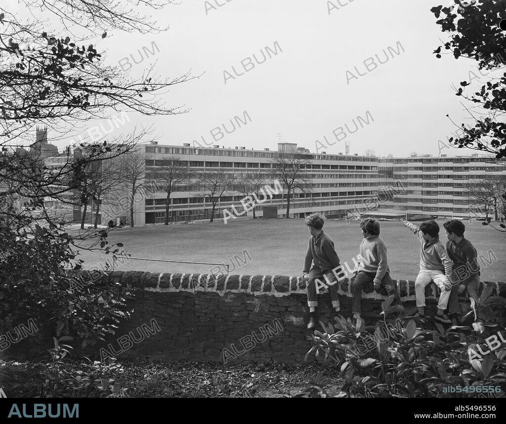 JOHN LAING PLC. Victoria Park Estate, Macclesfield, Cheshire East, Cheshire, 18/04/1968. Four boys sitting on a stone wall, looking towards flats in the distance at the Victoria Park development, built using the 12M Jespersen system. In 1963, John Laing and Son Ltd bought the rights to the Danish industrialised building system for flats known as Jespersen (sometimes referred to as Jesperson). The company built factories in Scotland, Hampshire and Lancashire producing Jespersen prefabricated parts and precast concrete panels, allowing the building of housing to be rationalised, saving time and money. The Victoria Park development in Macclesfield, lying between the park and the centre of town, was built by Laing in two phases using the 12M Jespersen system. Providing around 500 flats, the design consisted of thirteen interlinked blocks forming a series of courts with landscaped gardens. The first phase was completed in 1968 with the second phase started in the same year.