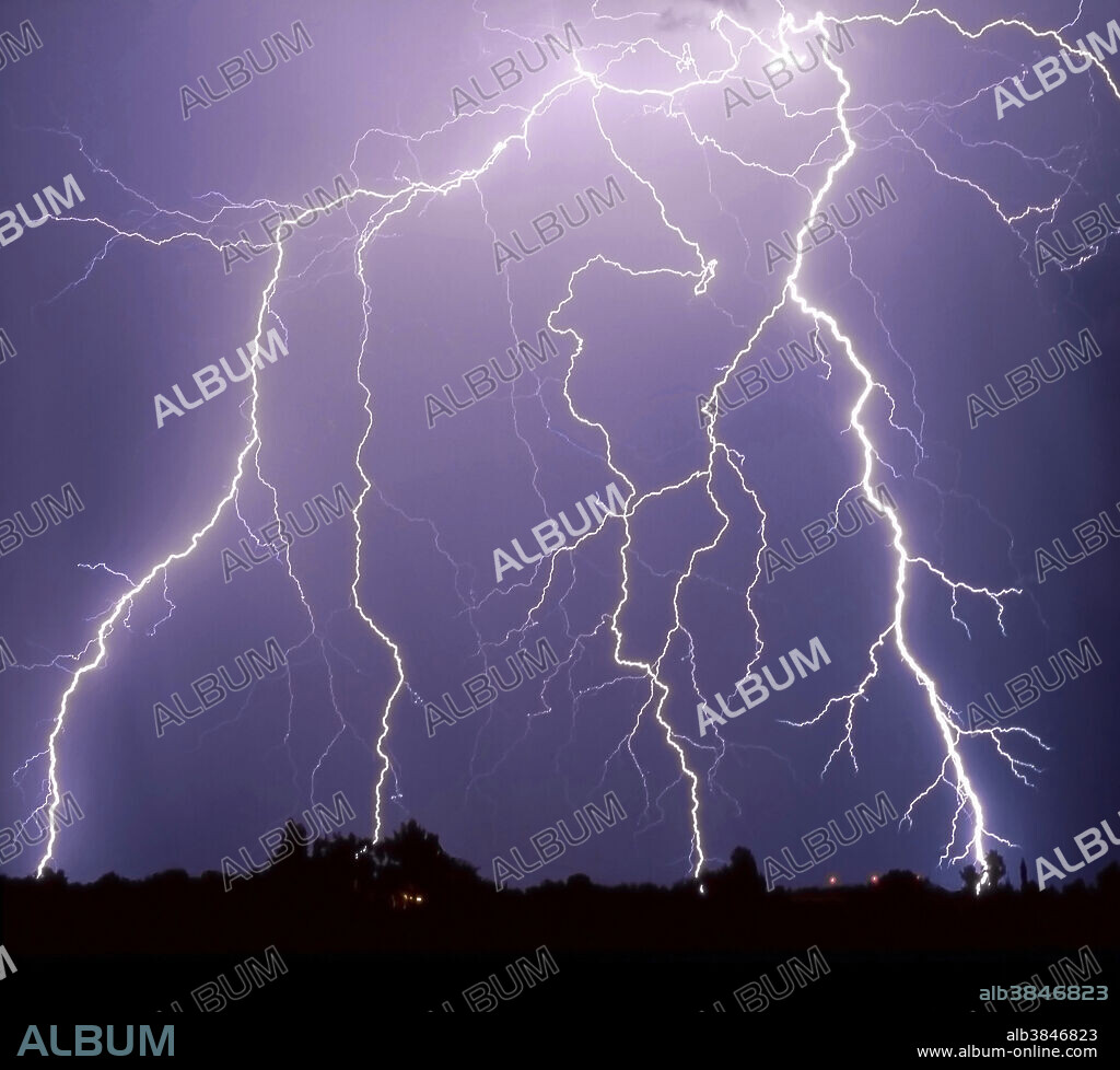 This long-exposure photograph of a summer thunderstorm shows long cloud-to-ground lightning bolts; Tucson, Arizona. The Arizona desert experiences many intense thunderstorms, with powerful gust fronts, heavy rain, hail and lightning, during the summer months. The storms are caused by moist air from the Pacific Baja or the Gulf of Mexico mixing with hot, dry air rising up from the heated desert floor.