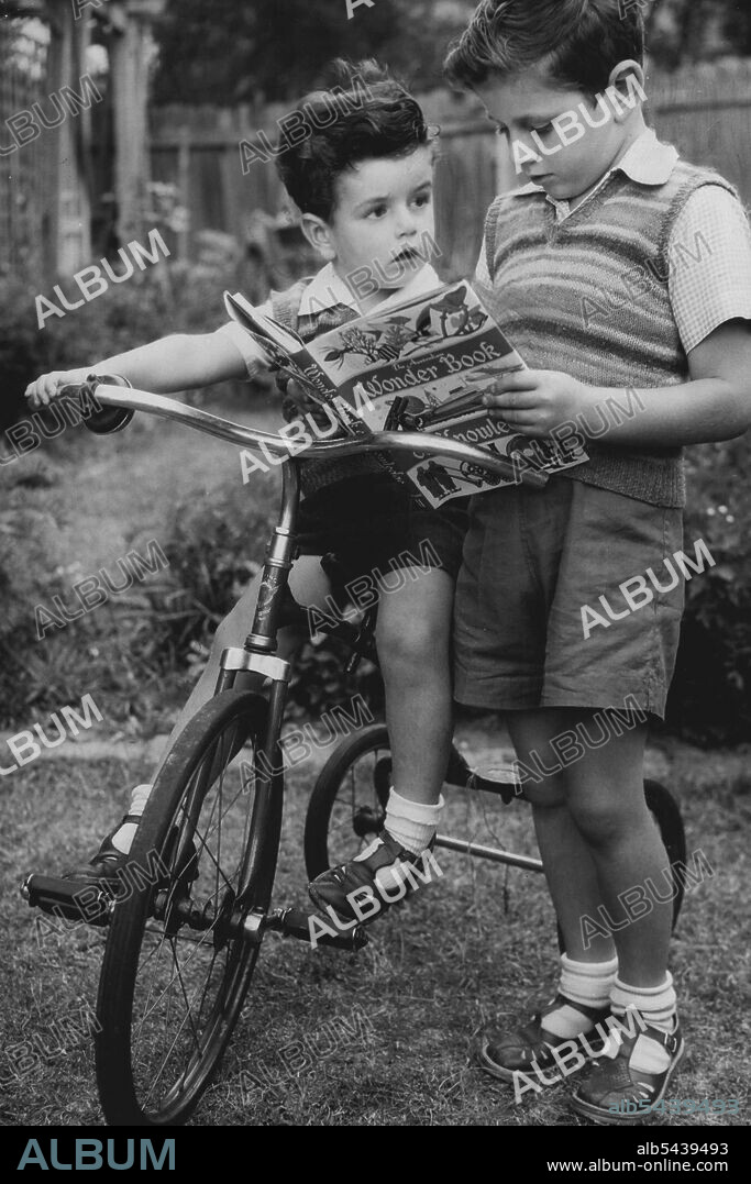 Peter Brown, 7, shows the Australian Wonder Book of Knowledge Volume 2 to his brother Stephen, 4. April 28, 1953.