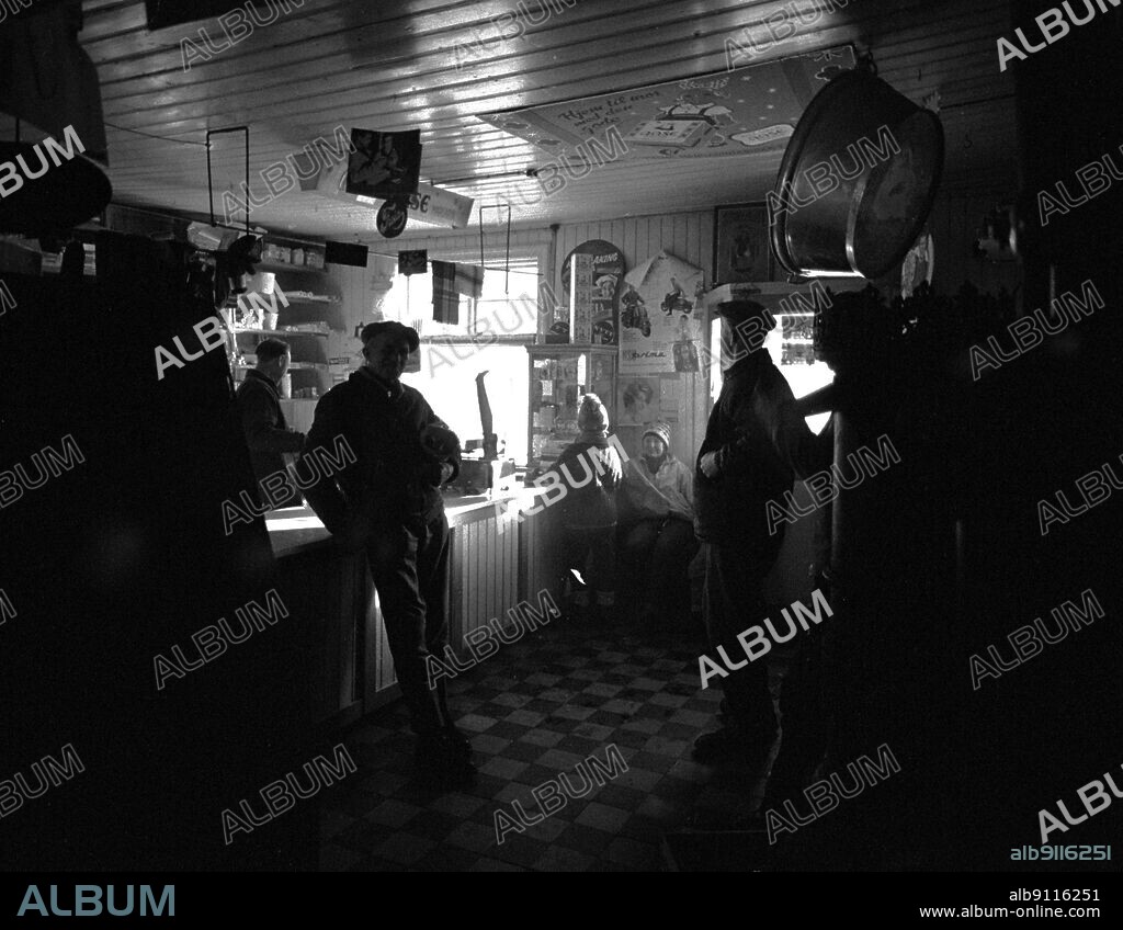 Rukkedalen in Hallingdal 1963 From the old land trader in Rukkedalen in Hallingdal. Krambu. Country trade. Owner Arne S. Eidal behind the counter. Customer in front of the counter. Motlight. Photo: Sverre A Børretzen / Current / NTB   Supplementary information: Eidal Landhandel in Rukkedalen has been elected to the Millennium for Nes in Buskerud in the year 2005.