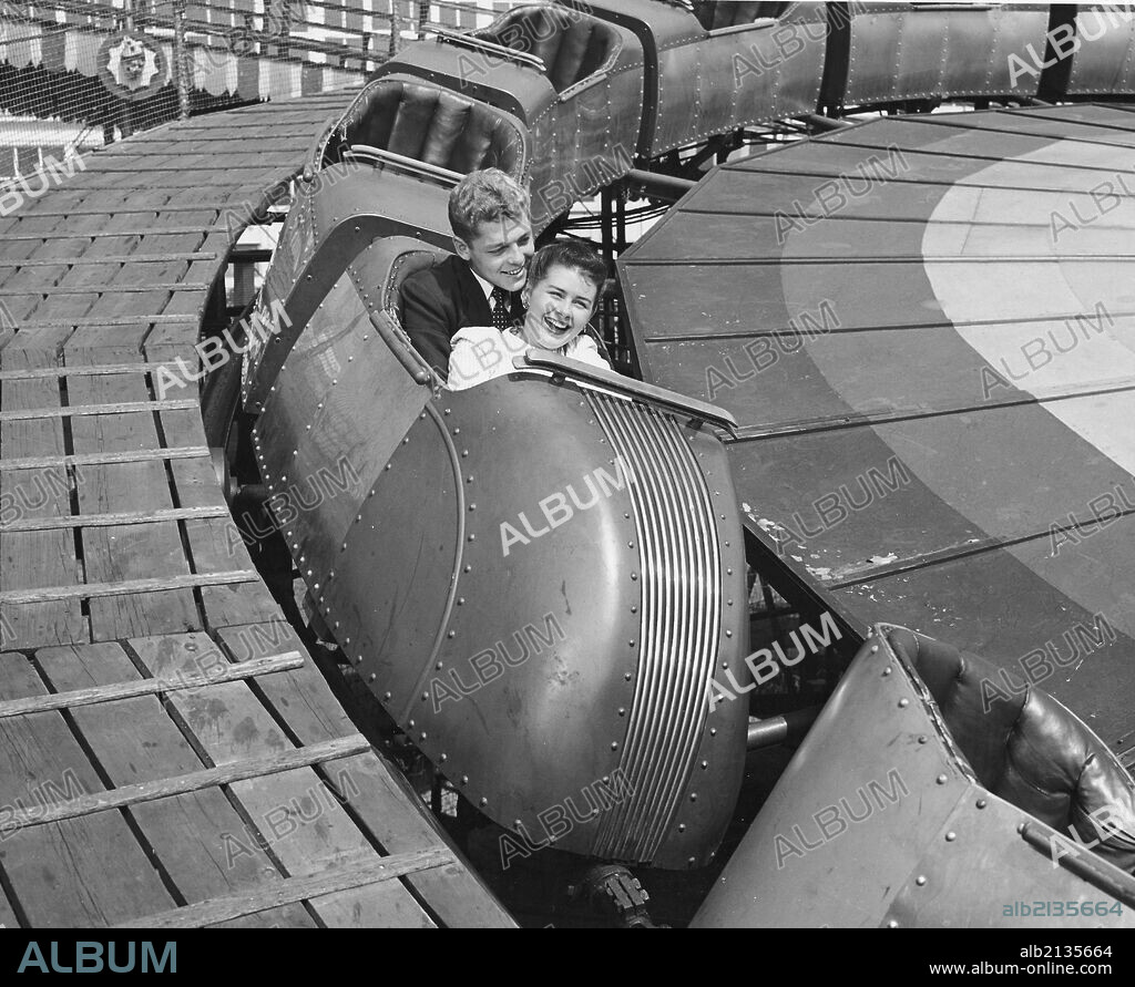 Teenage couple on roller coaster, Coney Island, New York, 1950s, black and white.