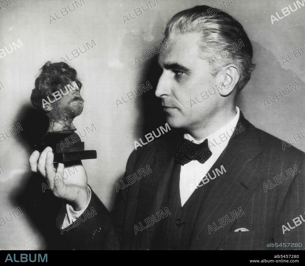 Evidence In War Crimes Trial -- Thomas Dodd, an assistant prosecuting attorney for the  U.S. at the Nurenberg, Germany, War crimes trial, holds a human shrunken head he introduced as evidence of cruelty in German concentration camps. December 20, 1945. (Photo by AP Wirephoto).