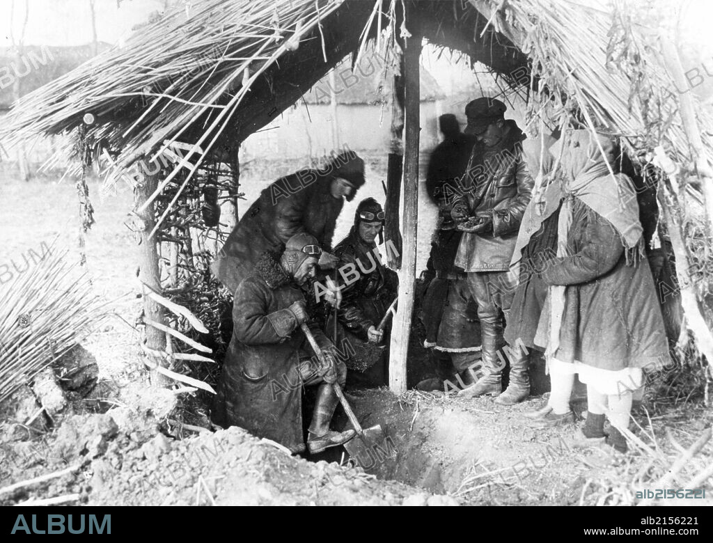 Kolkhoz (collective farm) workers discover a cache of rotting wheat hidden near a kulak (rich peasant) 's house, kurgansky region, soviet union, 1932.