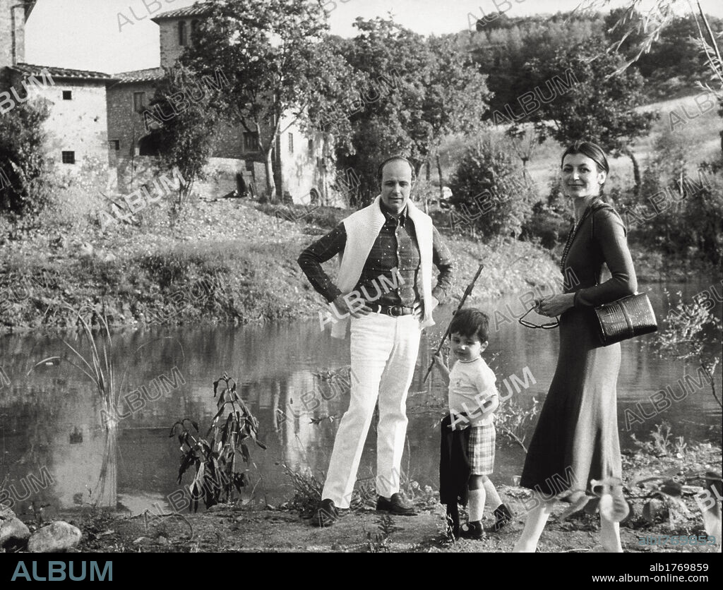 Carla Fracci. The Italian dancer Carla Fracci, her husband  Beppe Menegatti and their son Francesco walk along the banks of a stream, in their farm. Tuscany, 1972.