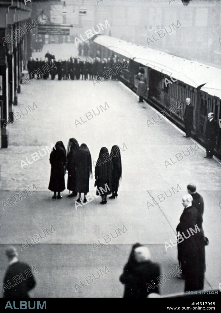 Queen Mary, the Princess Royal and the daughter's in law of the late King George V, wait for his coffin at King's Cross station London. Funeral of King George V (1936), King of the United Kingdom and the British Dominions, and Emperor of India, from 6 May 1910 until his death in 1936. the four sons of the late king (King Edward VIII, the Duke of York, the Duke of Gloucester and the Duke of Kent) take part in the state funeral.