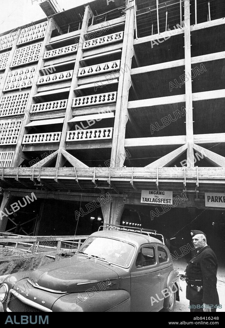 Stockholm 1964-05-04. Taklagsfest hölls på måndagen för Stockholms största parkeringshus, Parkaden, vid Regeringsgatan. 400 personer som slitit med detta pampiga niovåningarshus á minst 22 milj kr festade i dess källarvåning och gladdes åt att det blir parkeringspremiär redan i juni och total inflyttning i september i år. Huset, ritat av arkitekt Hans Asplund, får två våningar under jord där får bl a NK ett storlager en bottenvåning med butiker, snabbköp, systembolag och cafeteria och där ovanpå sex våningar plus takterrass med platser för 850 bilar. En krona i timmen kommer det att kosta att parkera här: för ett månadskort får man ge 150 kr.. Foto: Bengt Almquist / DN / TT / Kod: 1. ** SvD OUT **.