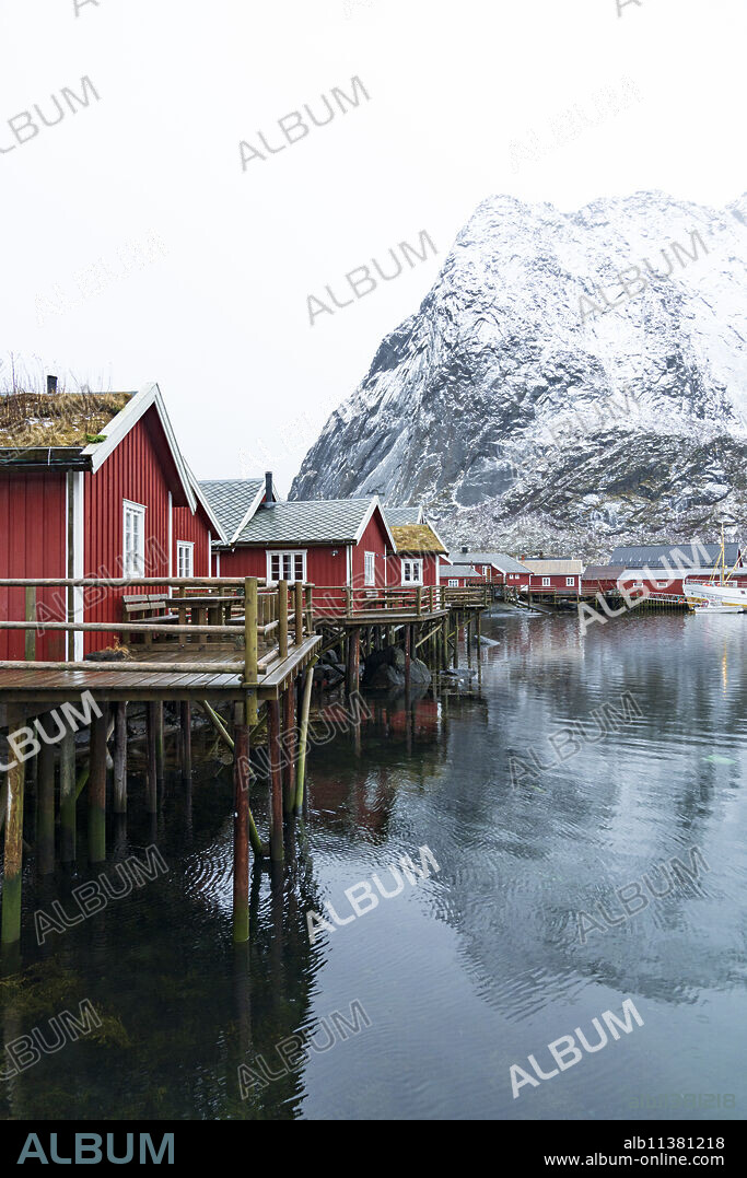 Red Rorbu cabins with grass roof in the small port of Reine, Nordland county, Lofoten Islands, Norway, Scandinavia, Europe.