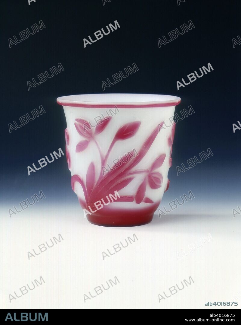Peking glass cup, white with pink overlay, Qing dynasty, China, c1800. An overlay glass cup of slender form. The body is decorated with a continuous band of flowering plants, the glass is of opaque white tone overlaid with bright pink.