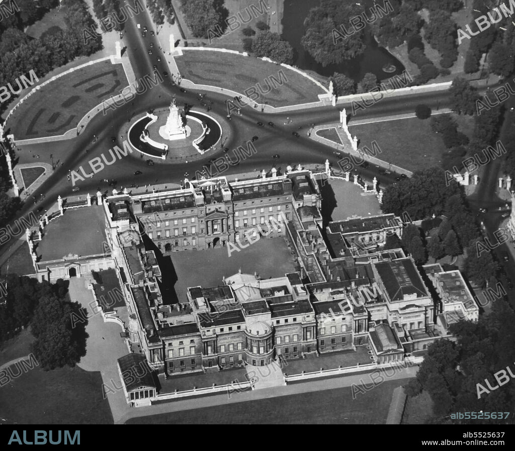 Buckingham Palace From The Air -- This view, taken from the west, illustrates the rear entrance the Principal Royal Palace. Facing the other side (the frontage) is ***** Queen Victoria Memorial, to the left of it, Green Park, to ***** right, St. James' Park. Buckingham Palace was purchased by ***** III, in 1762, from the Duke of Buckingham and was ***** for the King George IV. It has been the London ***** since Queen Victoria's accession in 1837.Buckingham Palace ..."Five tons of gold plate and jewels to take your breath away." March 01, 1955. (Photo by Camera Press).